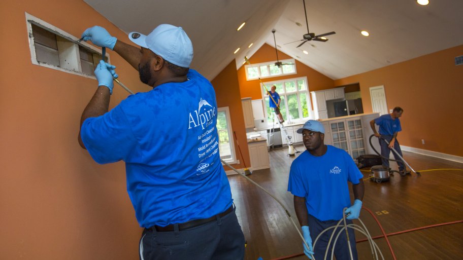 air duct cleaning crew using hose to clean air duct in home